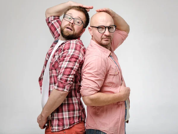 Men are measured by growth, they stood with their backs to each other as in childhood and are trying to determine who is taller. — Stock Photo, Image