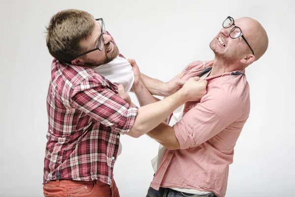 Conflito de amigos. Dois homens com óculos discutiram começaram a lutar, agarraram-se ferozmente a roupa um de outro e sorrindo . — Fotografia de Stock