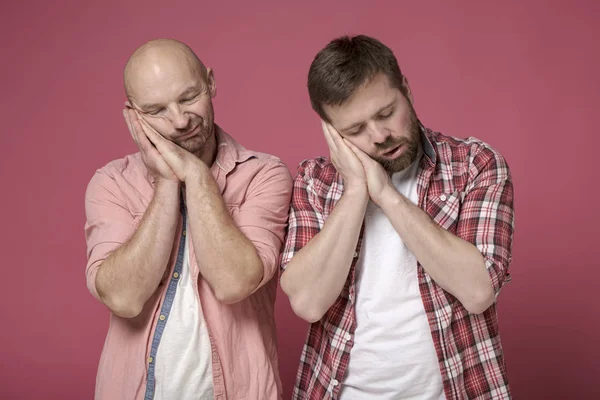 Dos hombres bromeando doblaron las palmas, las pusieron debajo de sus cabezas y fingieron estar durmiendo . — Foto de Stock