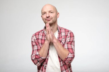 Kel adam avuçlarını katladı ve kameraya bakıp af diledi..