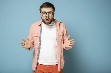 Its impossible. Stunned bearded man opened his mouth in surprise and looks with big eyes into the camera.