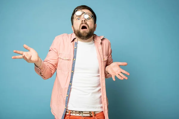 Aturdido, atrapado desprevenido hombre con gafas distorsionadas en la cara, arroja las manos en el desconcierto y abrió la boca de shock . — Foto de Stock