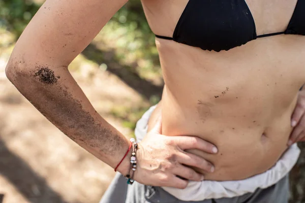 Kvinnlig kropp, hand, mage är smutsiga med jord och sot från en lägereld, i ett läger på en solig sommardag. — Stockfoto