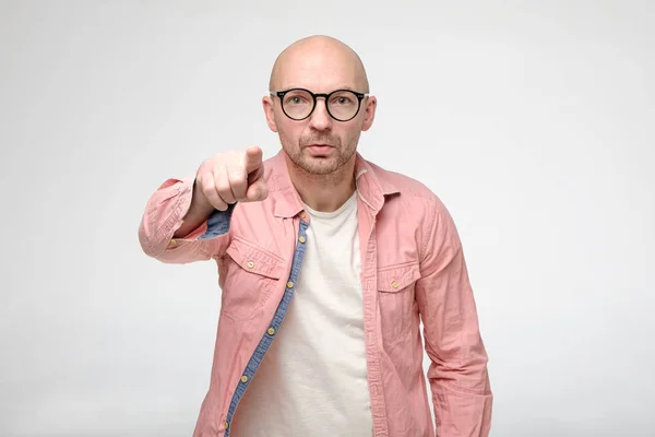 Worried man accuses someone by pointing finger at the guilty person and looks at the camera with a serious look. — Stock Photo, Image