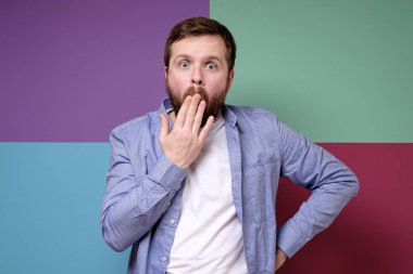 Beyaz sakallı adam şaşırdı ve şok oldu. Ağzını kapadı ve kameraya baktı..