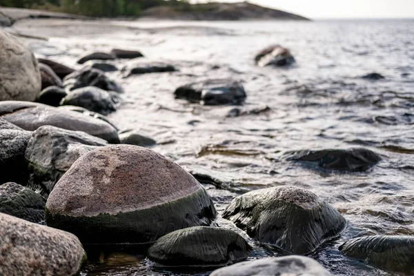 Rocky seashore, against the background of the sea with small waves, rocks and sky. Bottom view. — Stock Photo, Image