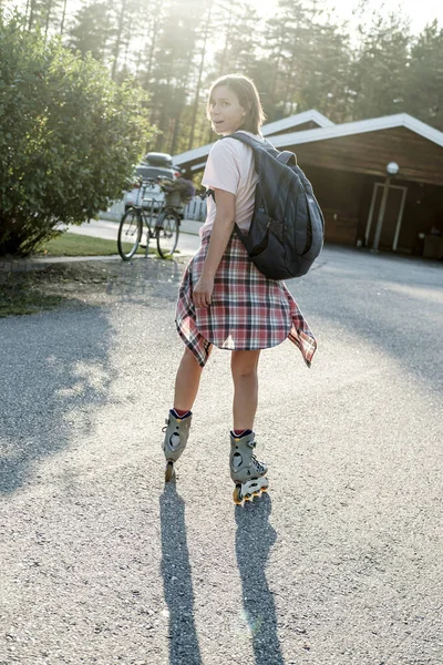 Mujer caucásica con mochila urbana patinaje sobre ruedas en un día soleado de verano. Vacaciones activas . —  Fotos de Stock