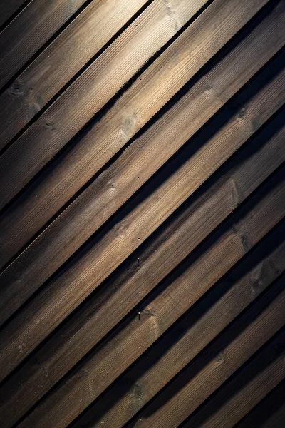 Drewniana ściana z odrobiną światła z góry. Może być używany jako tło. — Zdjęcie stockowe