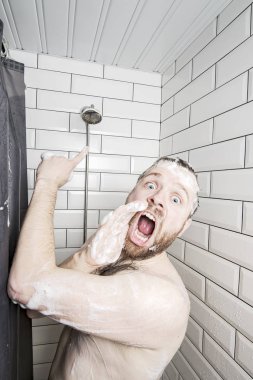 Man in soapy foam asks for help, because the shower runs out of water, he screams and points with index finger at the watering can