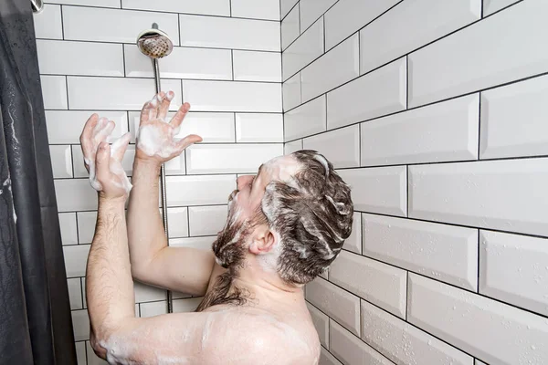 Shocked man in soap suds is scared and screaming because the soul has run out of water or something has broken. — Stock fotografie