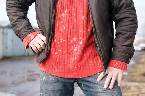Мужчина в грязной рабочей одежде, красный вязаный свитер и джинсы . — стоковое фото