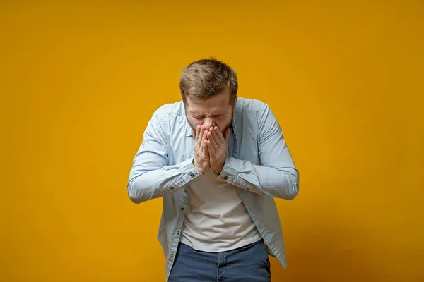 Hombre caucásico tose o estornuda mientras cubre la boca con palmas. Concepto de propagación del virus . —  Fotos de Stock