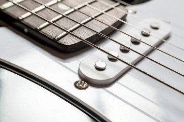 Body and neck with strings of a modern, electronic guitar, close-up.