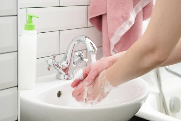 Lavarse las manos con jabón líquido bajo el agua corriente para protegerse contra un virus peligroso. Concepto de salud. Primer plano . — Foto de Stock