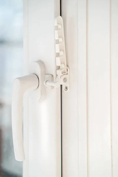 Janela de PVC branca fechada, com dispositivo de fixação acoplado para ventilação. Close-up . — Fotografia de Stock