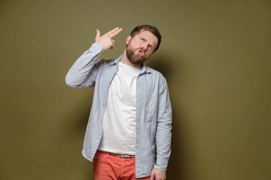 Adam parmağıyla kafasını işaret etti, sanki bir silahmış gibi ve duygusal ifadesiyle kendini vuracaktı. Stres kavramı.