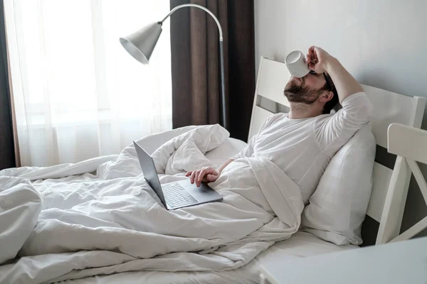 Vit Man Dricker Kaffe När Han Sitter Sängen Pyjamas Han — Stockfoto