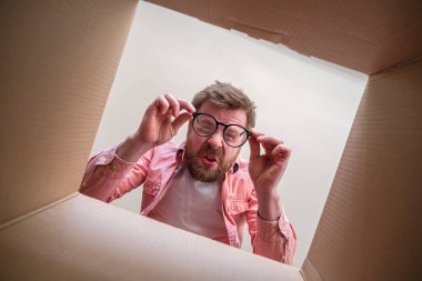 Garip bir adam, paketlenmemiş bir kutunun dibine bakıyor. İçinde hayal kırıklığına uğramış bir paket var. İçerideki kutucuğu aç.