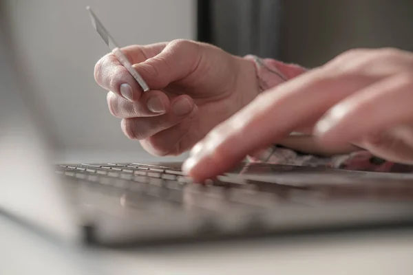 Hände geben die Bankdaten einer Kreditkarte auf einem Laptop ein, um Online-Einkäufe zu bezahlen. Konzept der Selbstisolierung. Moderner Lebensstil. — Stockfoto