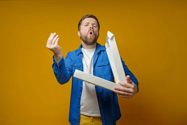 Un hombre divertido trajo pizza a una reunión con amigos, abrió la caja y emocionalmente, con un gesto, muestra lo delicioso que es . — Foto de Stock