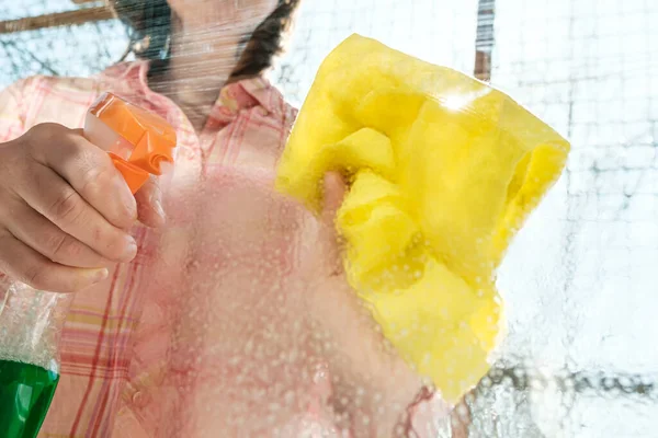 A mulher lava um copo de janela de pó e sujeira, usando um spray com detergentes e trapos, em um dia ensolarado de primavera. Conceito de limpeza . — Fotografia de Stock