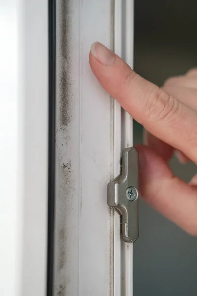 Zeigefinger zeigt auf den Schmutz auf dem weißen PVC-Fensterrahmen. Konzept der Sauberkeit. — Stockfoto