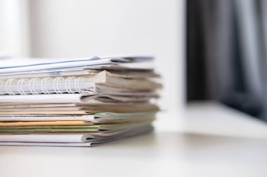 Pencerenin beyaz pencere pervazına yığılmış farklı not defterleri..