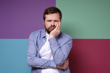 Bunalımlı, üzgün, Kafkasyalı bir adam avucunun içine aldı ve dalgın görünüyor..