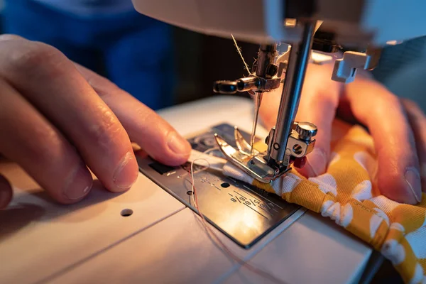 Mani maschili cucire una maschera protettiva utilizzando una moderna macchina da cucire elettrica. Concetto di sicurezza durante un'epidemia virale . — Foto Stock