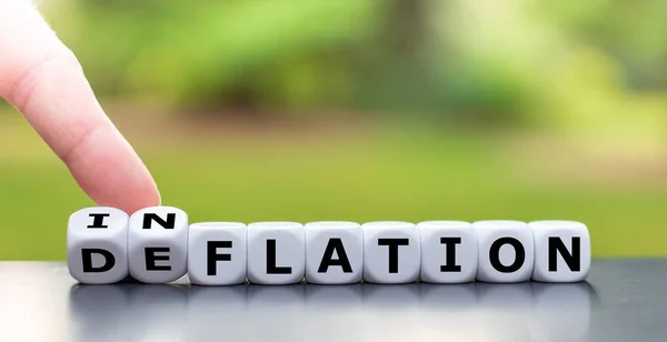 Hand turns a dice and changes the word "deflation" to "inflation — Stock Photo, Image