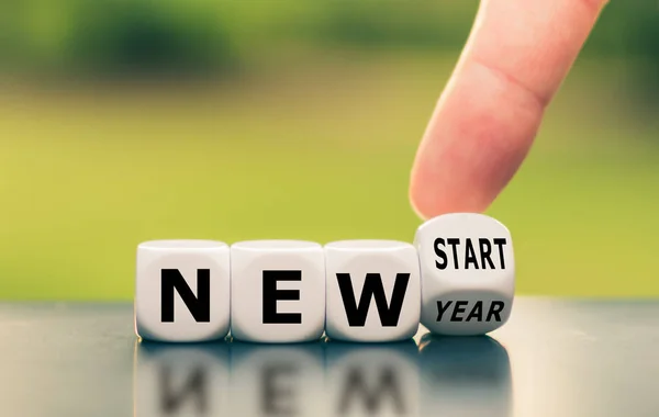 Hand turns a dice and changes the expression "new year" to "new — Stock Photo, Image