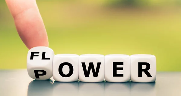 Hand turns a dice and changes the word "power" to "flower". — Stock Photo, Image