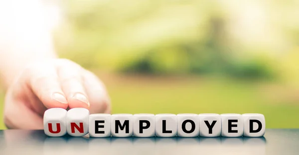 La mano gira un dado e cambia la parola "disoccupati" in "occupati" — Foto Stock