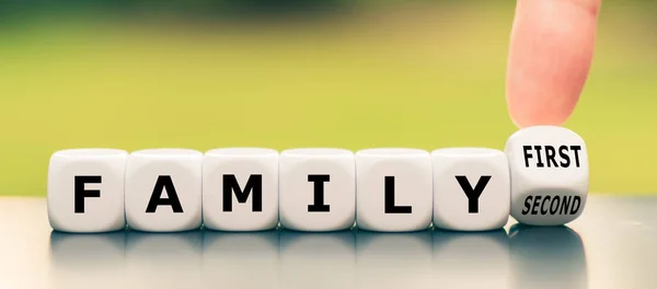 Hand turns a dice and changes the expression "family second" to — Stock Photo, Image