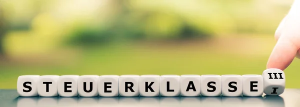 Hand draait een dobbelsteen en verandert de Duitse uitdrukking "Steuerklass — Stockfoto