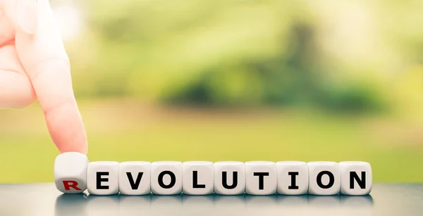 Evolution instead of revolution. Hand turns a dice and changes t — Stock Photo, Image