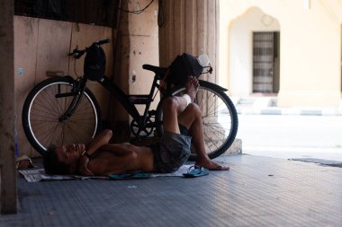 Yorgun asiat uyku adam ve yerde bisiklet yakınındaki sakin ol