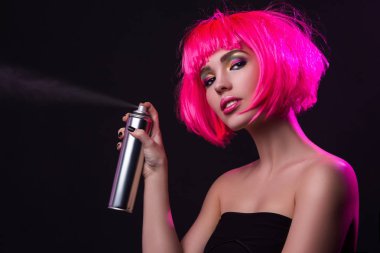 saç spreyi kullanarak pembe saçlı kadın 