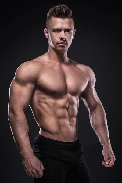 Young bodybuilder showing his muscles — Stock Photo, Image