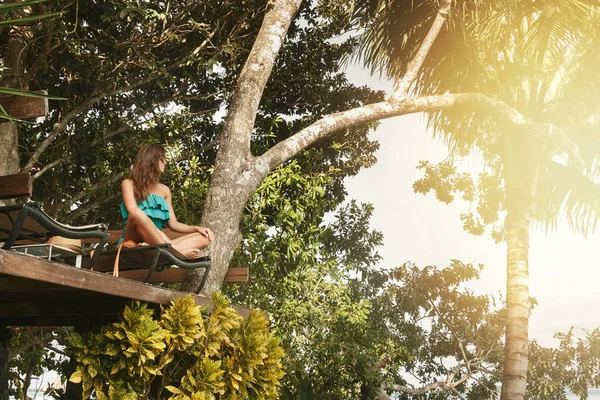 Счастливая девушка на платформе у дерева — стоковое фото
