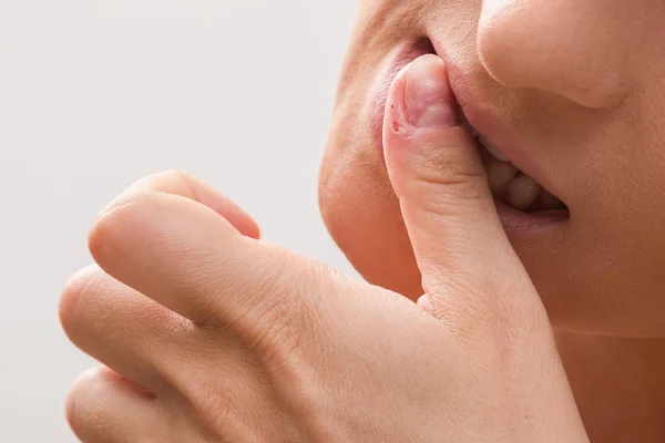 Женщина кусает палец — стоковое фото