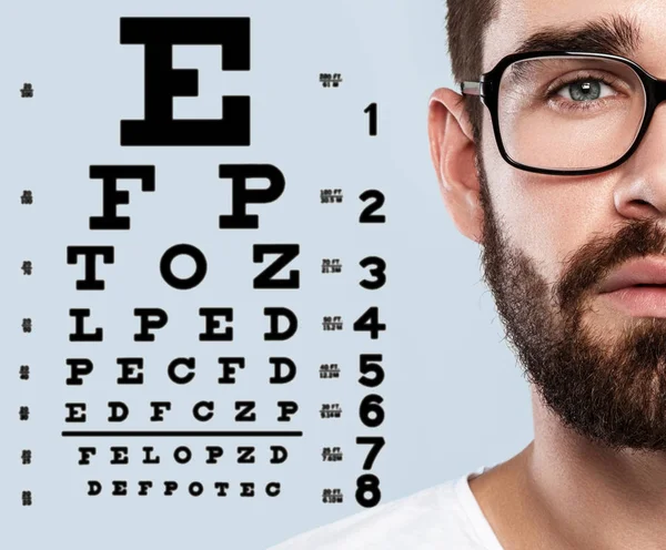 Half of male face and eye chart — Stock Photo, Image