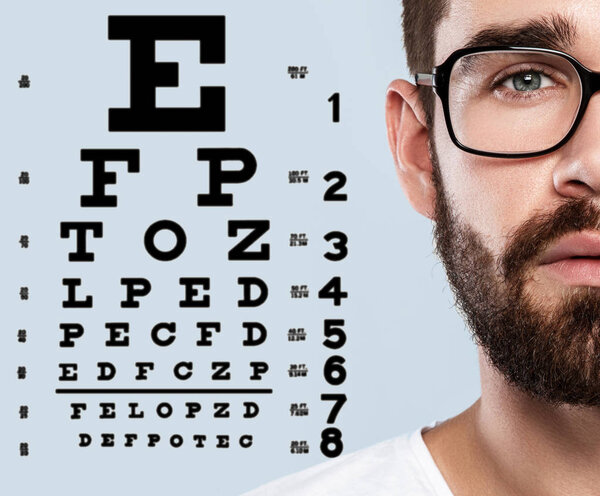 Half of male face and eye chart