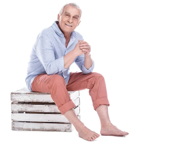 Elderly man sitting on wooden box — Stock Photo, Image