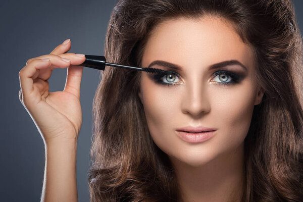  young woman applying mascara