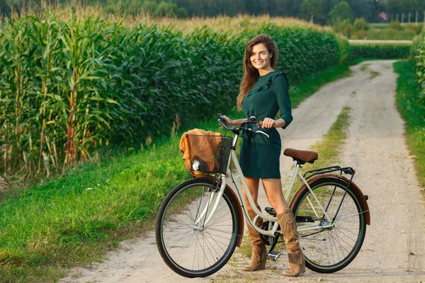 Žena s kolo na venkovské silnici — Stock fotografie