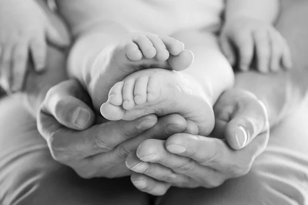 Fathers hands holding baby feet — Stock Photo, Image