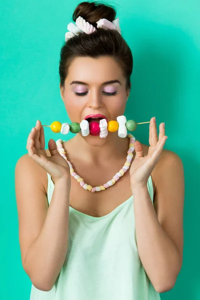 Kobieta z słodkie cukierki na szpikulec — Zdjęcie stockowe