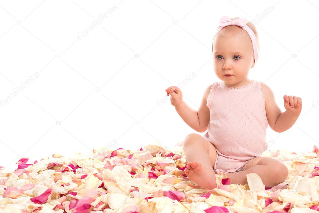Cute baby girl with rose petals