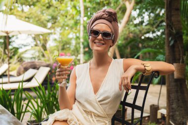 Lokantadaki masada portakal kokteyli içen mutlu kadın.